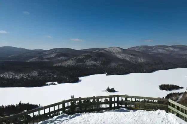 从 L'Hymne des Trembles 的 Mont Tremblant 小屋项目欣赏白雪皑皑的山峰